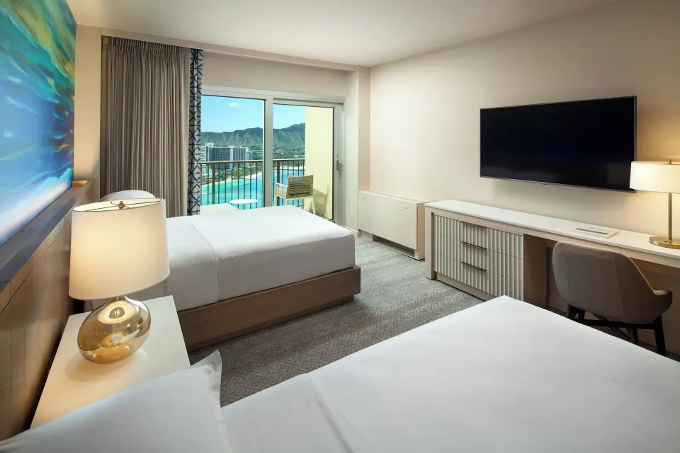 Oceanfront double-bed guest room with balcony view at Sheraton Waikiki Beach Resort.