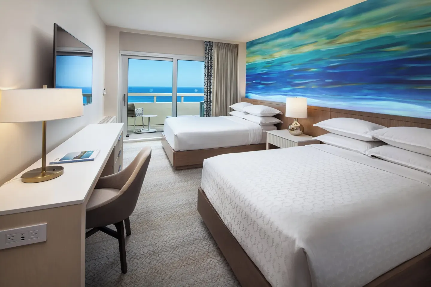 Oceanfront room with two beds and balcony at Sheraton Waikiki Beach Resort.