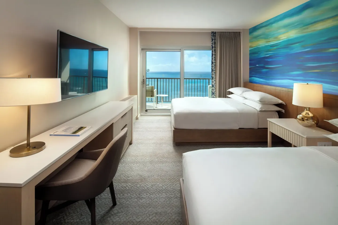 Oceanfront room with two beds, balcony, and ocean view at Sheraton Waikiki Beach Resort.