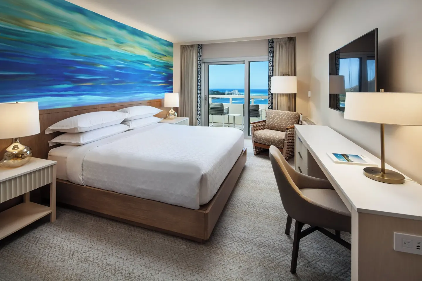Oceanfront king guest room with balcony at Sheraton Waikiki Beach Resort.