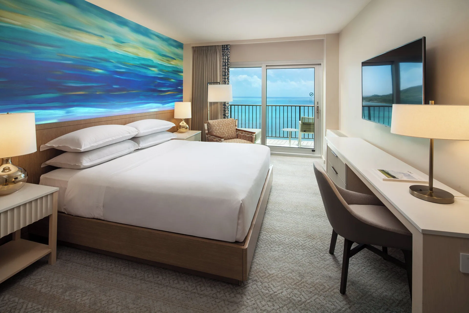Oceanfront king room with blue mural and balcony at Sheraton Waikiki Beach Resort.