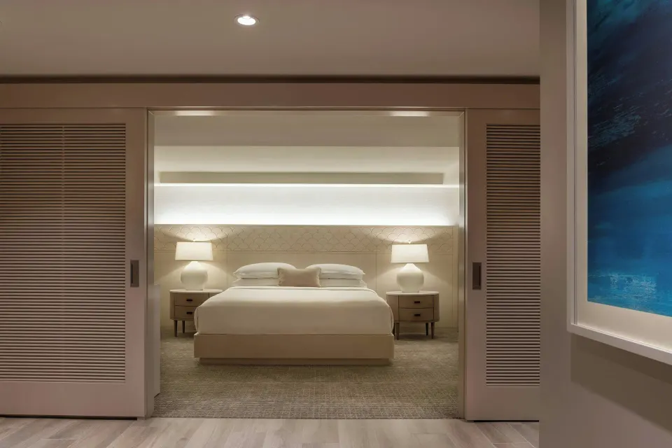 Malia Suite king bedroom seen through sliding doors at Sheraton Waikiki Beach Resort.