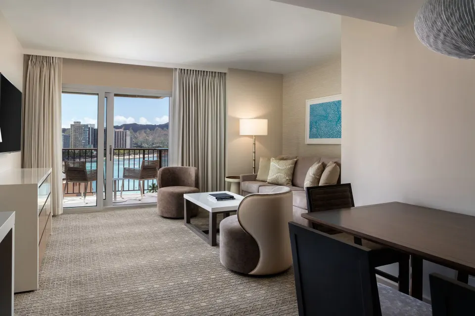 Malia Suite living room with balcony doors and Diamond Head view at Sheraton Waikiki Beach Resort.