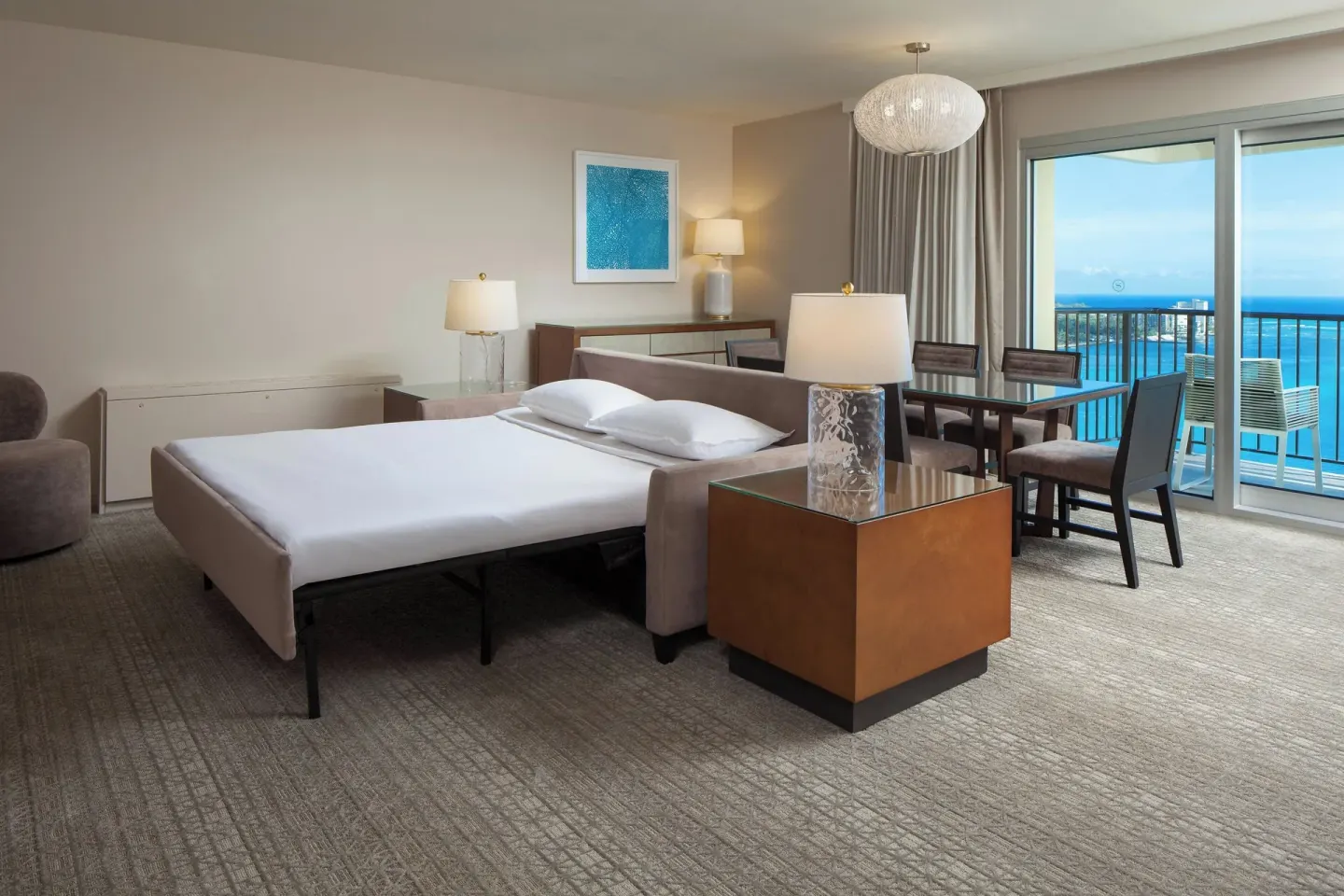 Kai Suite living area with sofa bed and ocean balcony at Sheraton Waikiki Beach Resort.