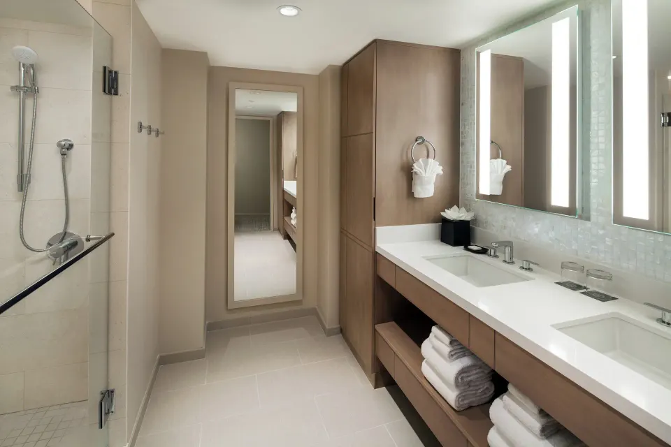 Double vanity bathroom with glass shower in the Ohana Suite at Sheraton Waikiki Beach Resort.