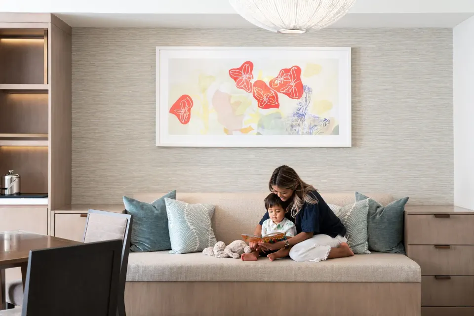 Built-in daybed seating with family reading in an Ohana Suite at Sheraton Waikiki Beach Resort.