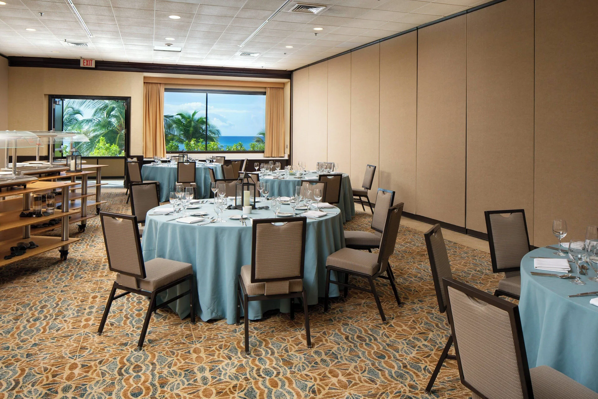 Banquet room with blue table linens and a buffet station at Sheraton Waikiki Beach Resort.