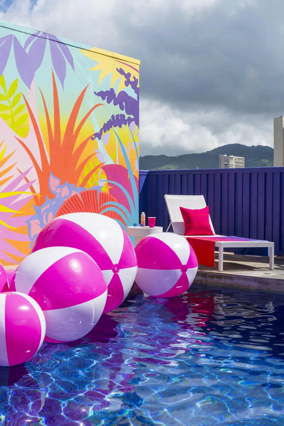 Pink beach balls floating by a pool lounger at Shoreline Hotel Waikiki.