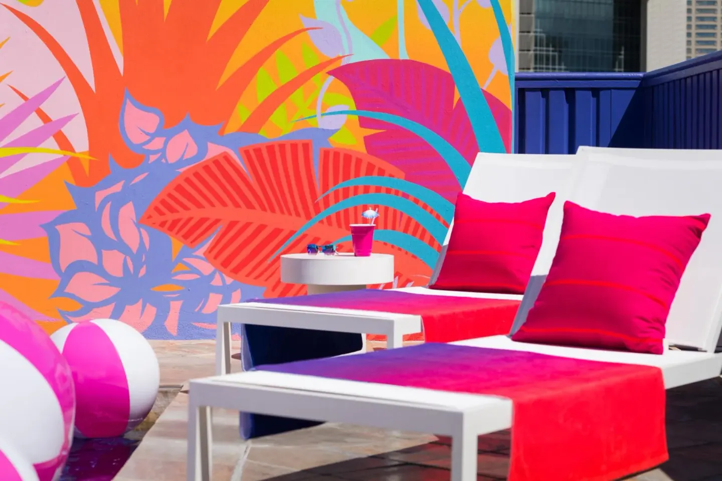 Poolside lounge chairs and tropical mural at Shoreline Hotel Waikiki.