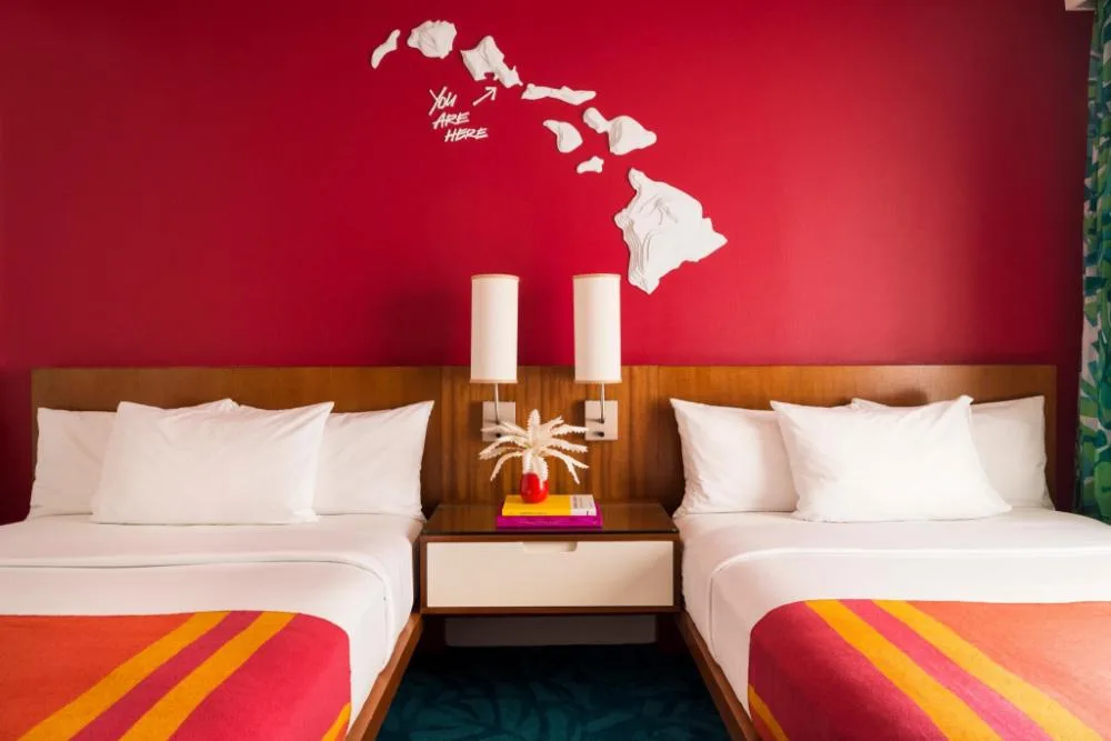 Two-bed guest room with island wall art at Shoreline Hotel Waikiki.