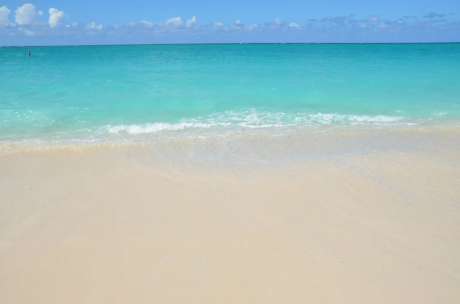 Close view of gentle waves on the beach at Sibonné Beach Hotel.