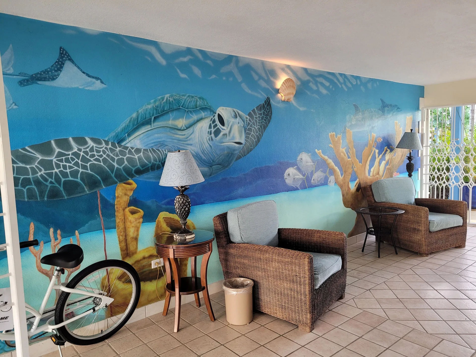 Lobby seating and an underwater sea turtle mural appear at Sibonné Beach Hotel.