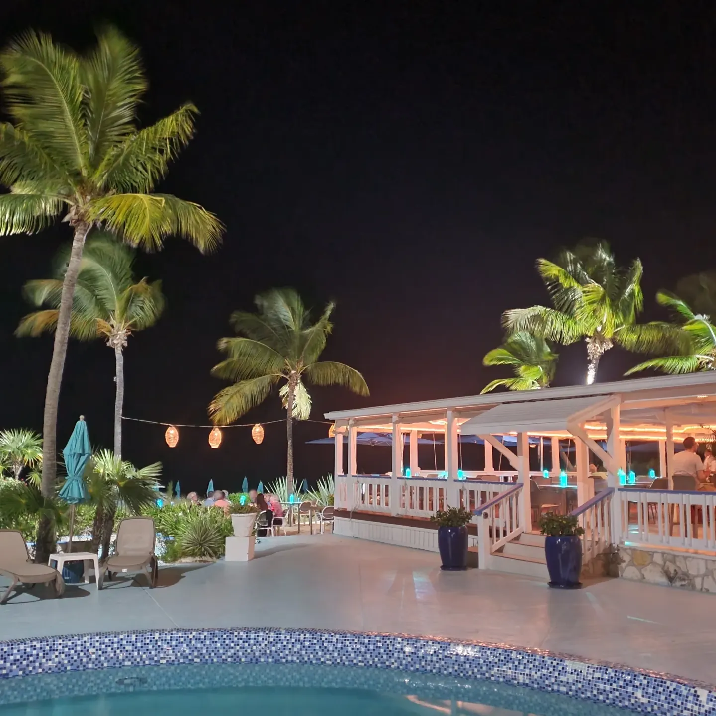 Nighttime pool and open-air dining pavilion at Sibonné Beach Hotel.