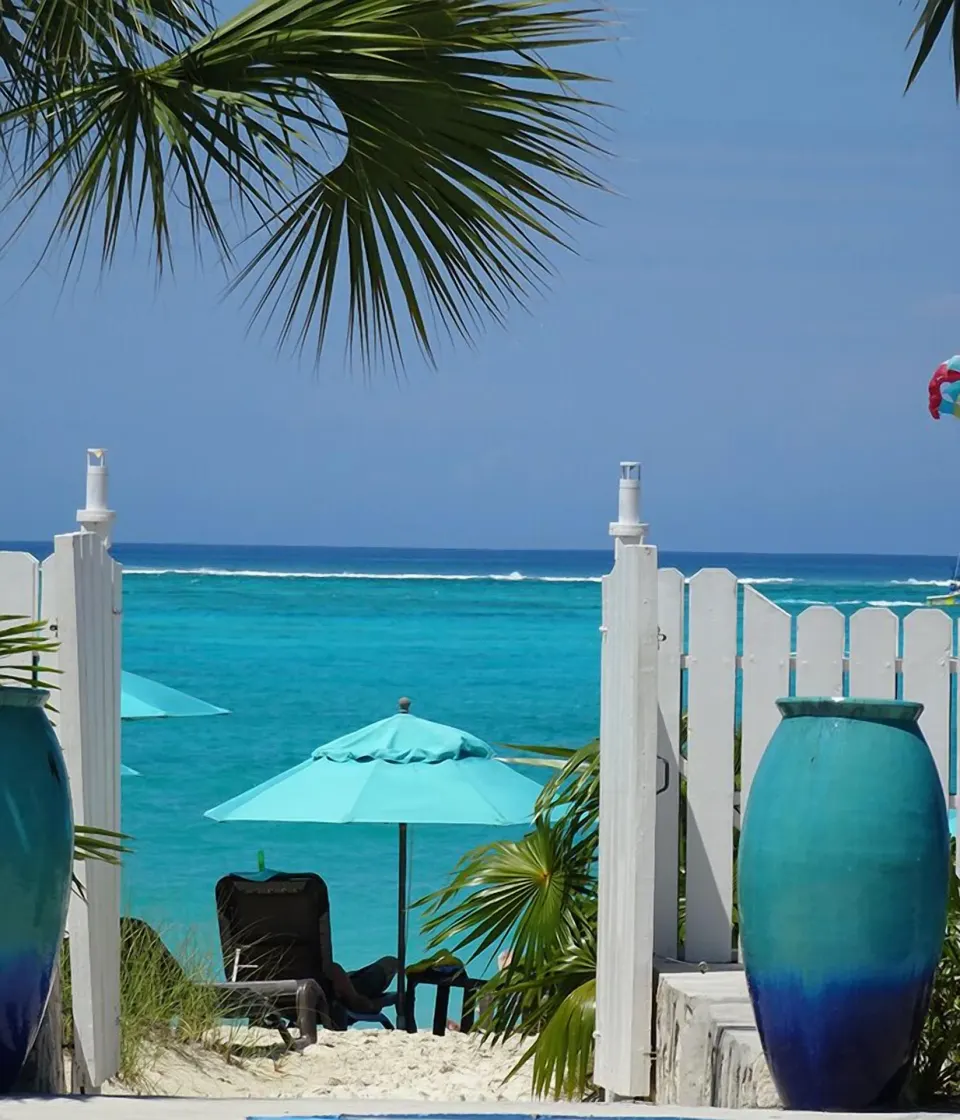 White gate, blue vases, and ocean view at Sibonné Beach Hotel.