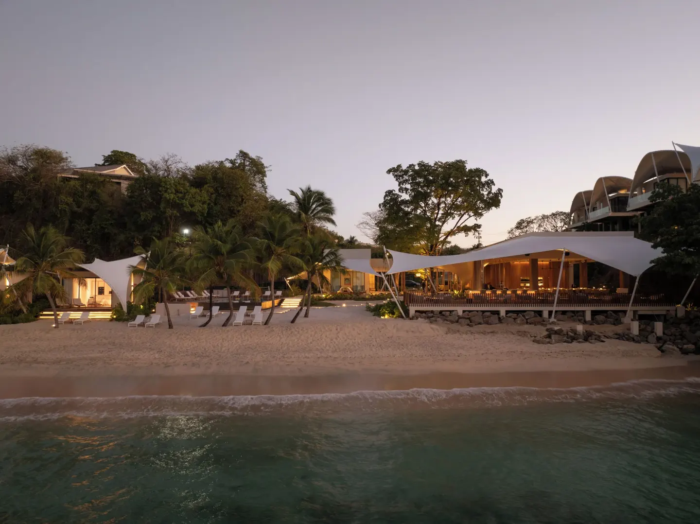 Beachfront buildings and palms at dusk at Silversands Beach House Grenada.