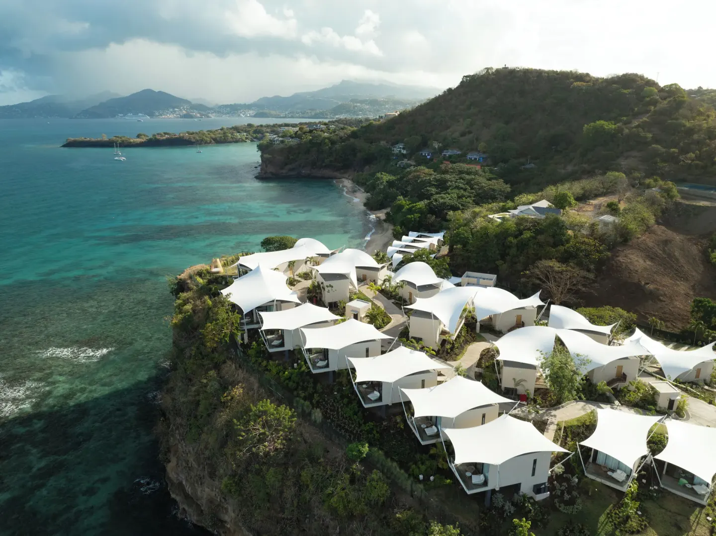 Aerial view of cliffside villas and turquoise bay at Silversands Beach House Grenada.
