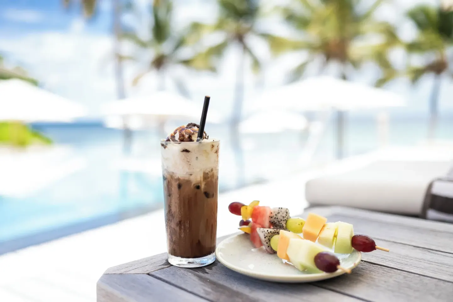 An iced drink and fruit skewers sit beside the pool at Silversands Beach House Grenada.