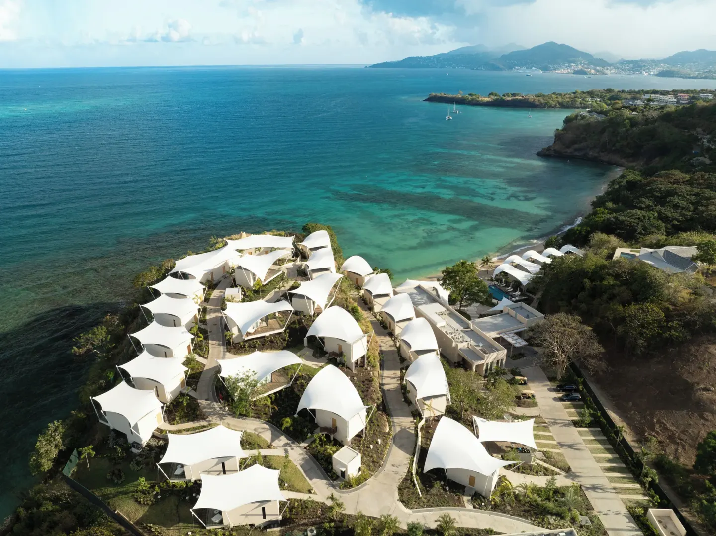 Aerial view of the resort beside a turquoise cove at Silversands Beach House Grenada.