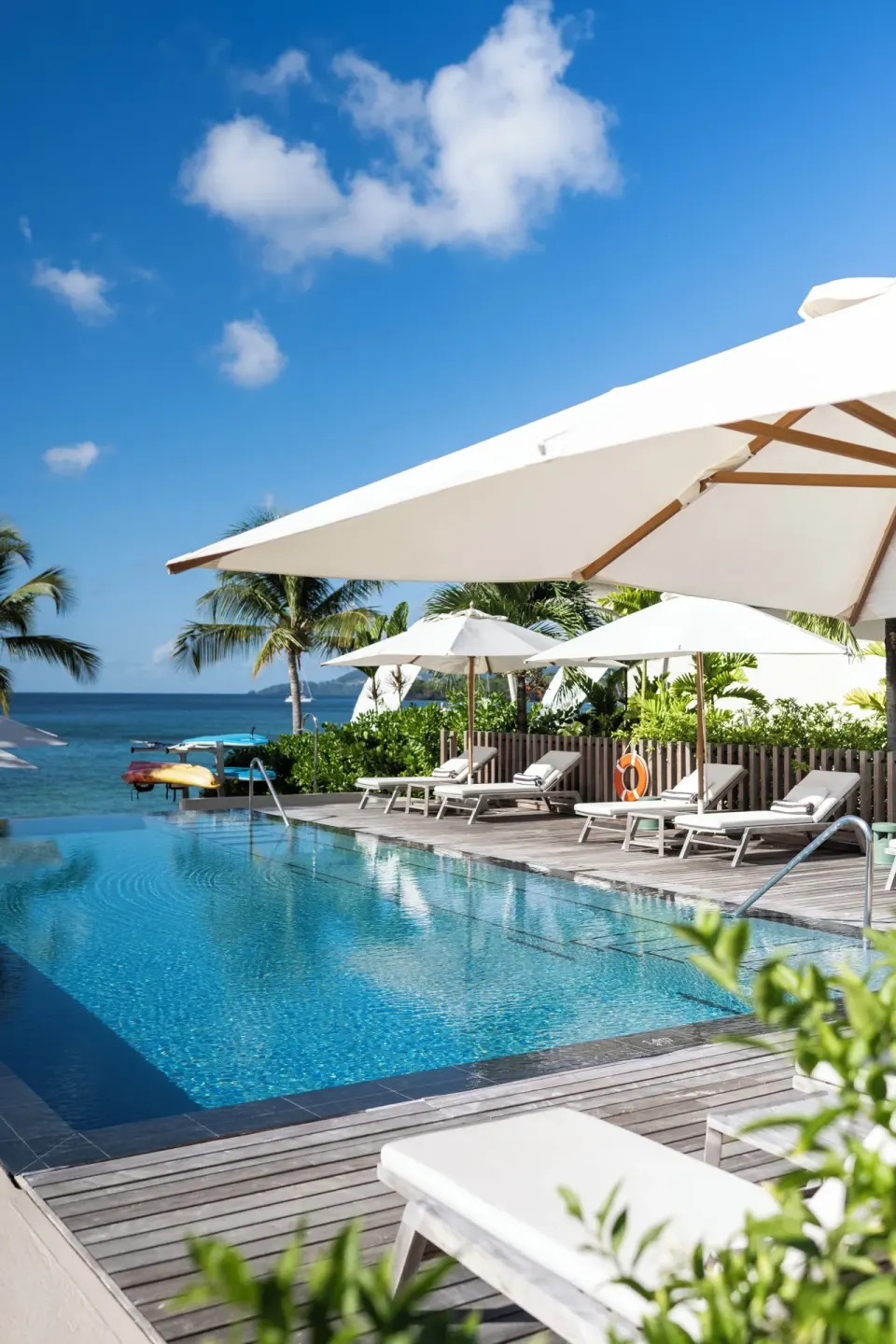 Sunny pool terrace with umbrellas and sea views at Silversands Beach House Grenada.