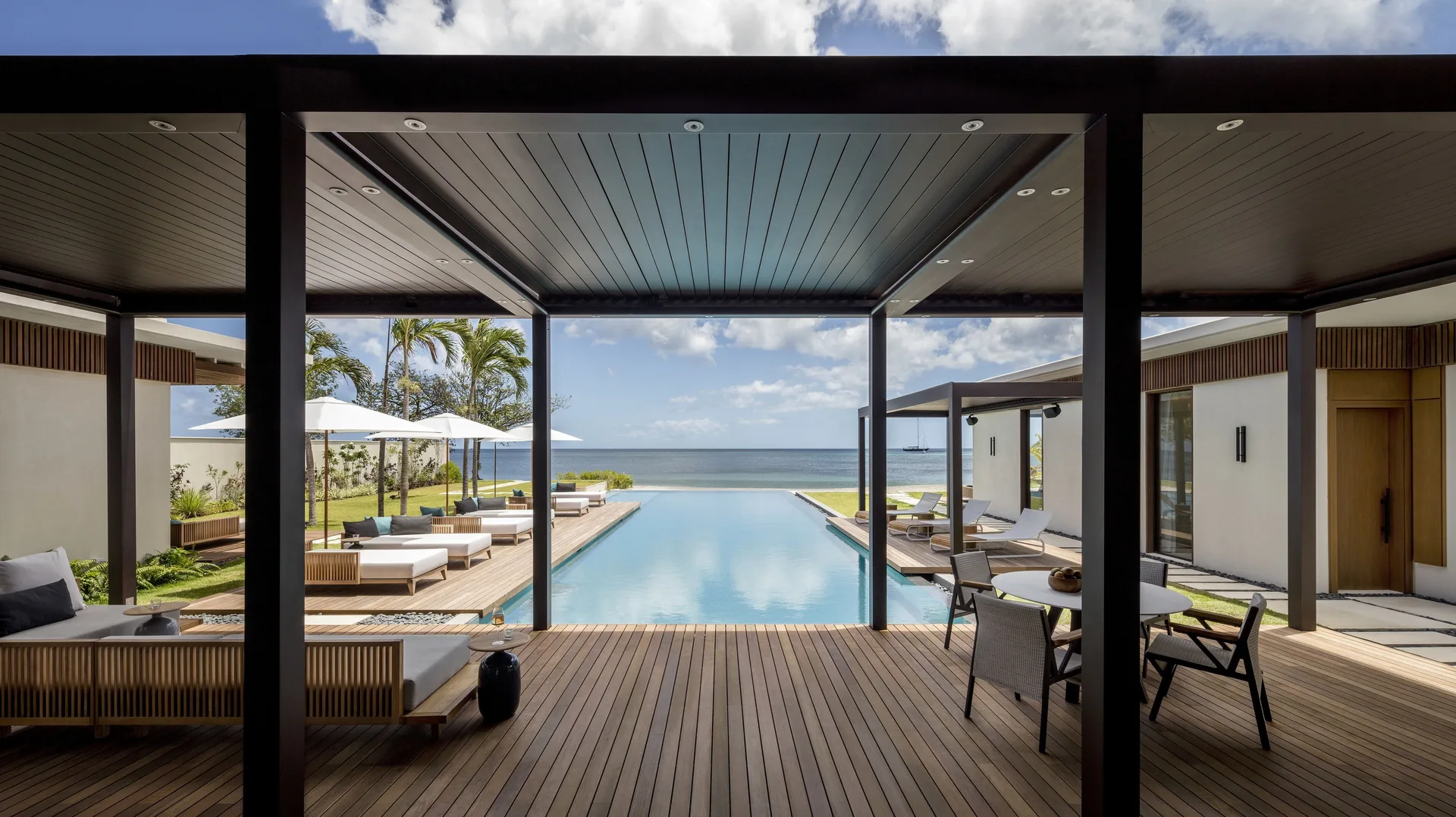 Covered villa deck with pool and ocean view at Silversands Beach House Grenada.