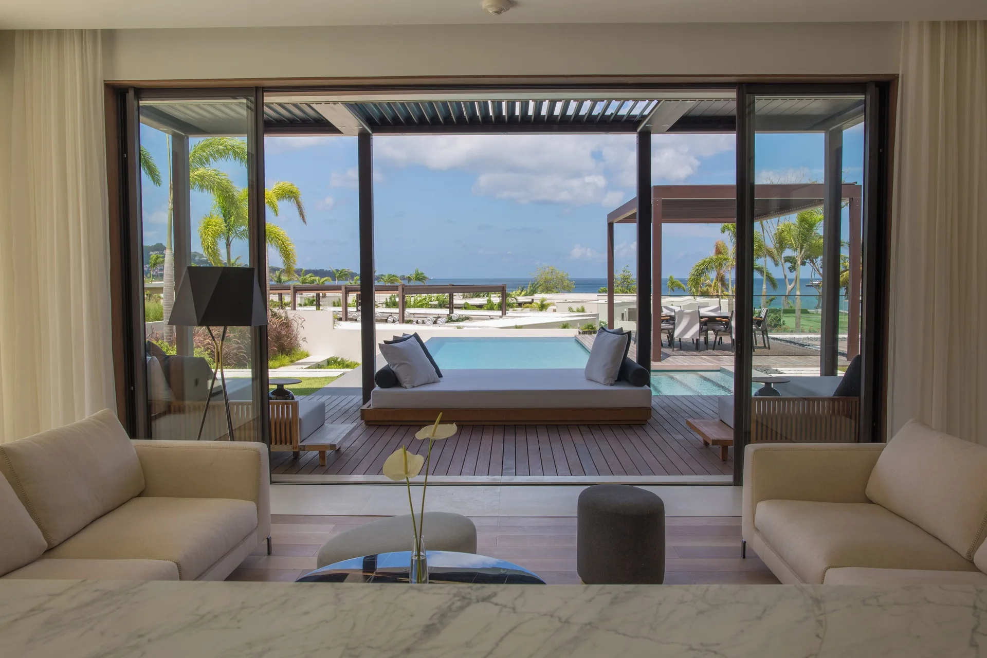 Oceanview villa living area opening to pool deck at Silversands Beach House Grenada.