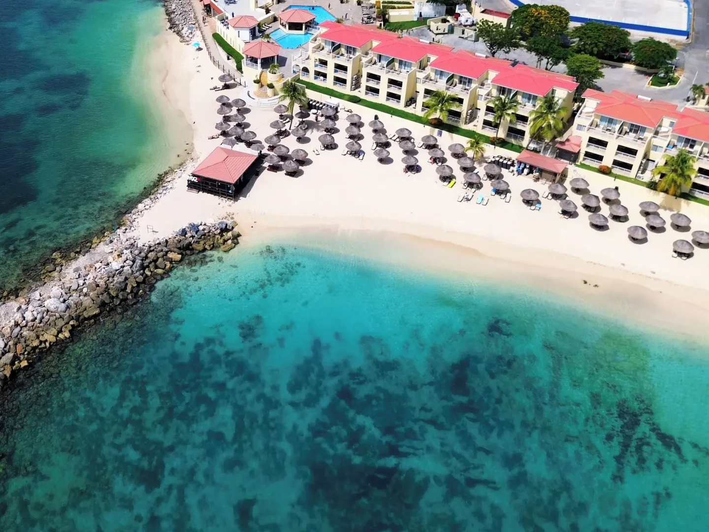 Aerial view of the sandy beach and clear water at Simpson Bay Resort, Marina & Spa.