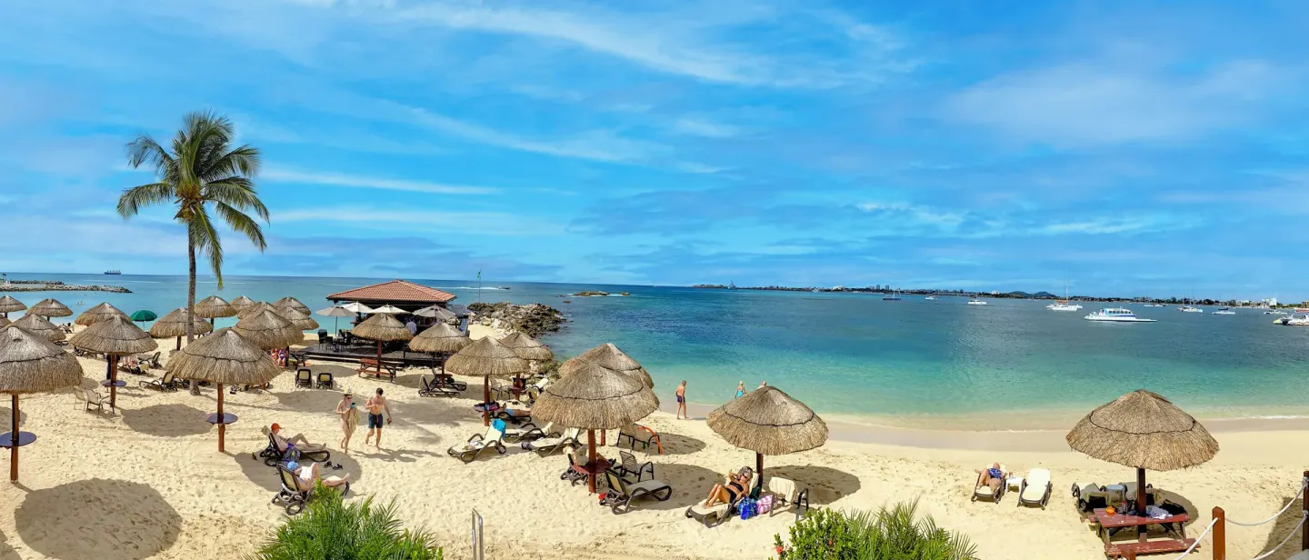 Beach with palapa umbrellas and lounge chairs at Simpson Bay Resort, Marina & Spa.