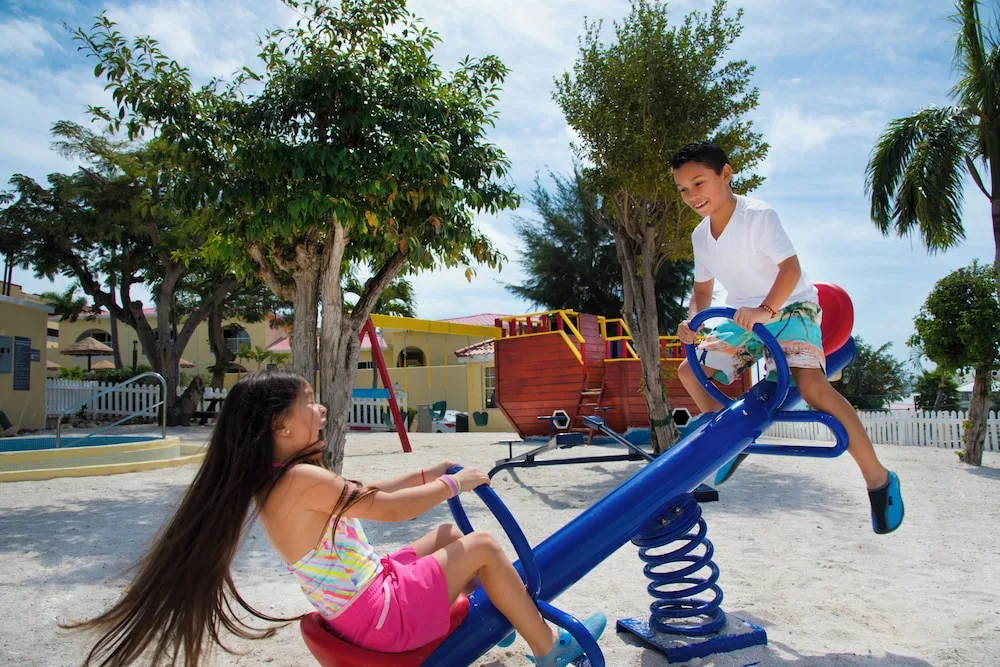 Children play on a seesaw in the playground at Simpson Bay Resort, Marina & Spa.