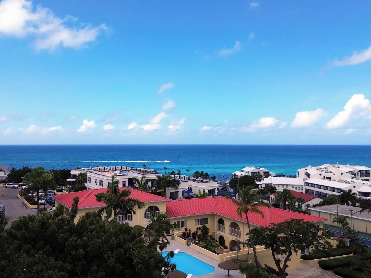 Resort buildings, pool, and ocean beyond at Simpson Bay Resort, Marina & Spa.