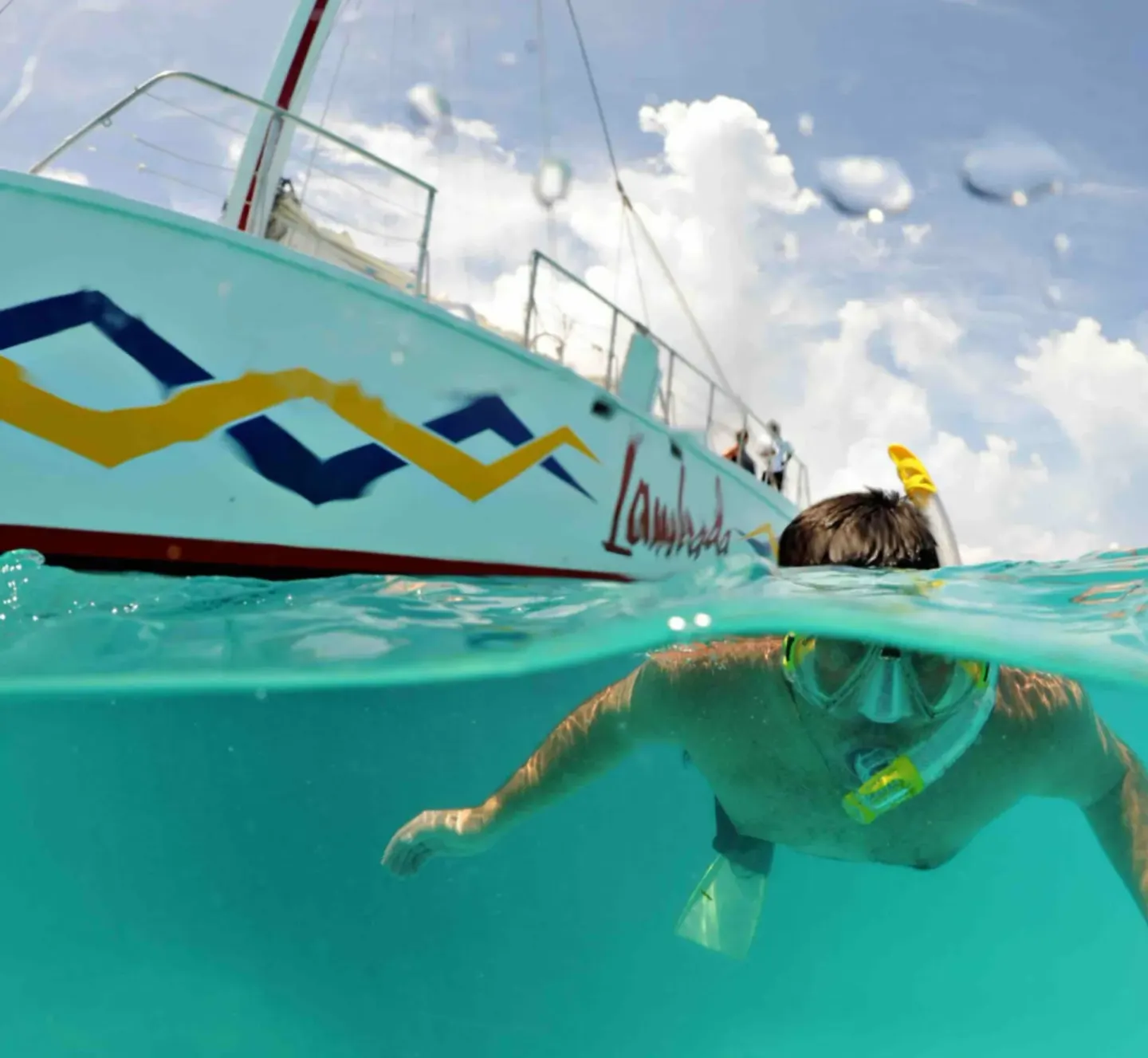 Snorkeler in clear water beside a boat near Simpson Bay Resort, Marina & Spa.