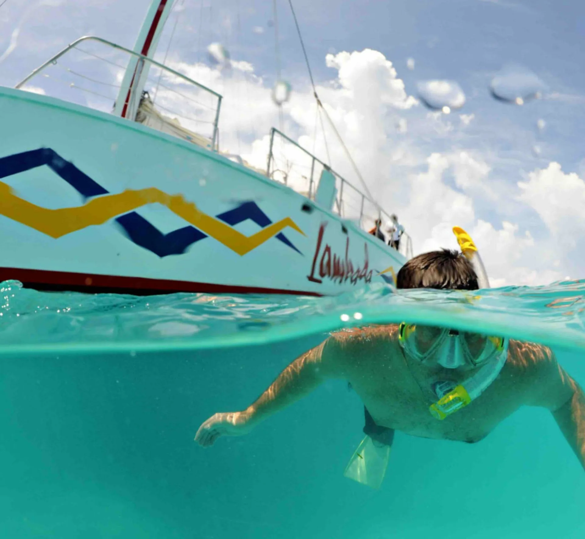 Snorkeler in clear water beside a boat near Simpson Bay Resort, Marina & Spa.