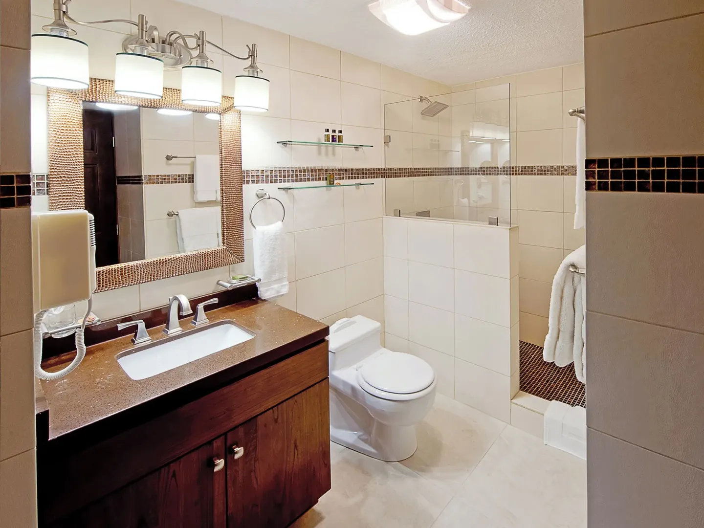 Tiled bathroom with vanity and glass shower at Simpson Bay Resort, Marina & Spa.