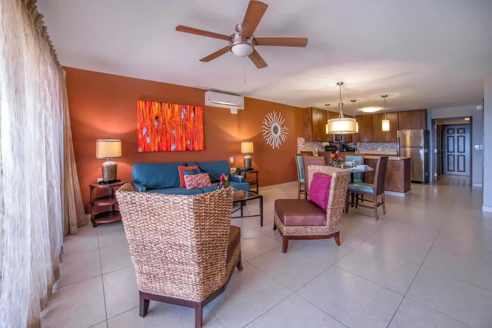 Deluxe Suite living room and kitchen at Simpson Bay Resort, Marina & Spa with sofas, chairs, and dining table.