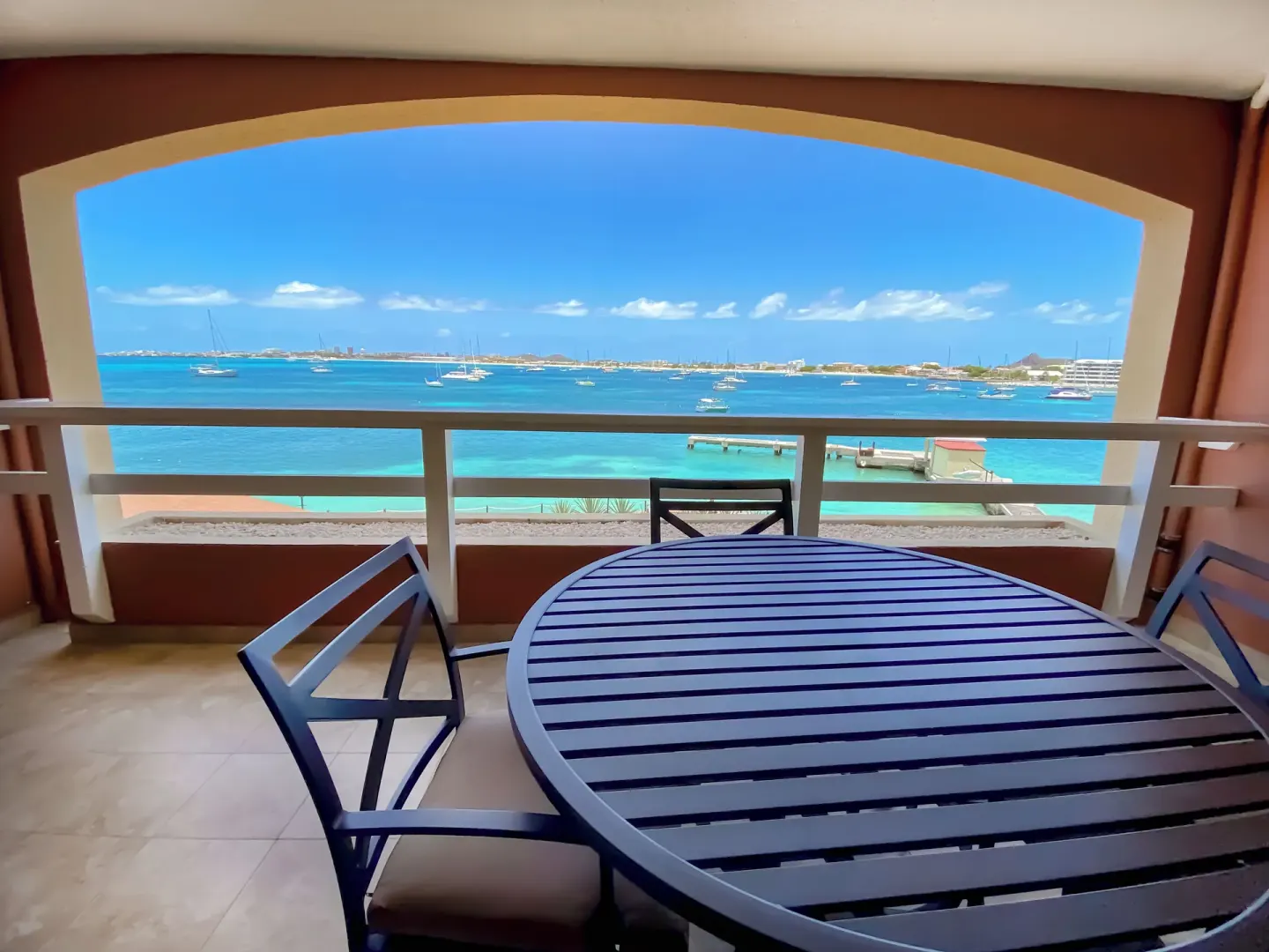 Oceanfront balcony dining table overlooking turquoise water at Simpson Bay Resort, Marina & Spa.