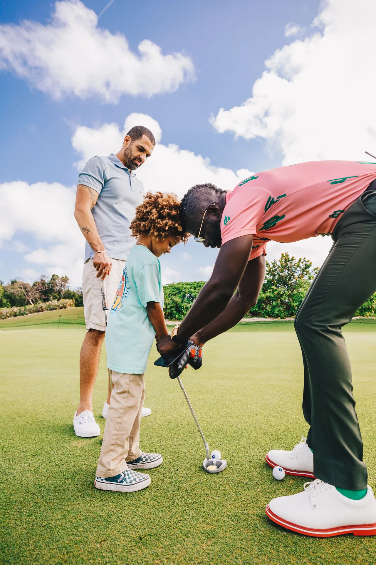 Golf instructor helping a child line up a putt at SLS Baha Mar.