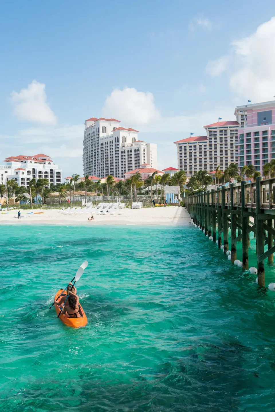 Kayaker paddling beside a pier and beach near SLS Baha Mar.