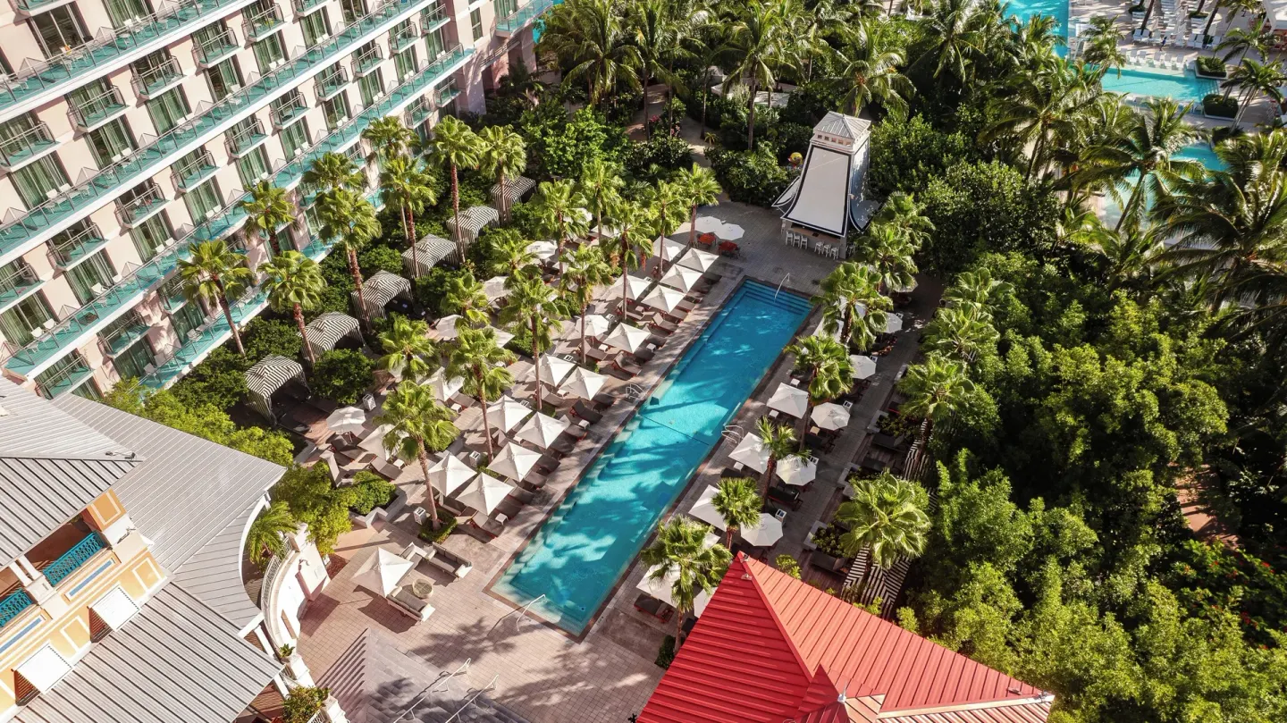 High-angle view of the pool courtyard, palms, and guest balconies at SLS Baha Mar.