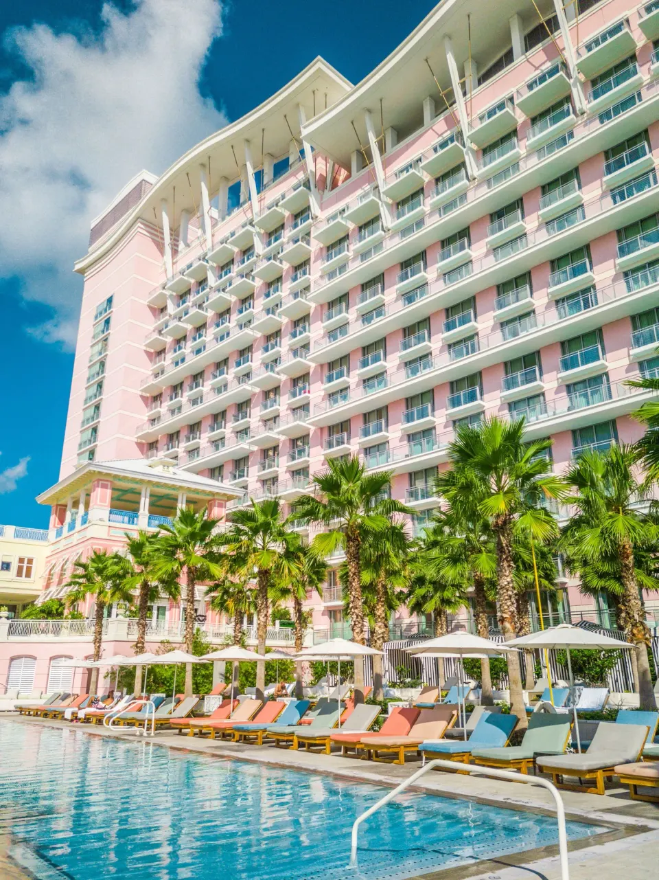 Pool loungers and the pink resort tower at SLS Baha Mar.