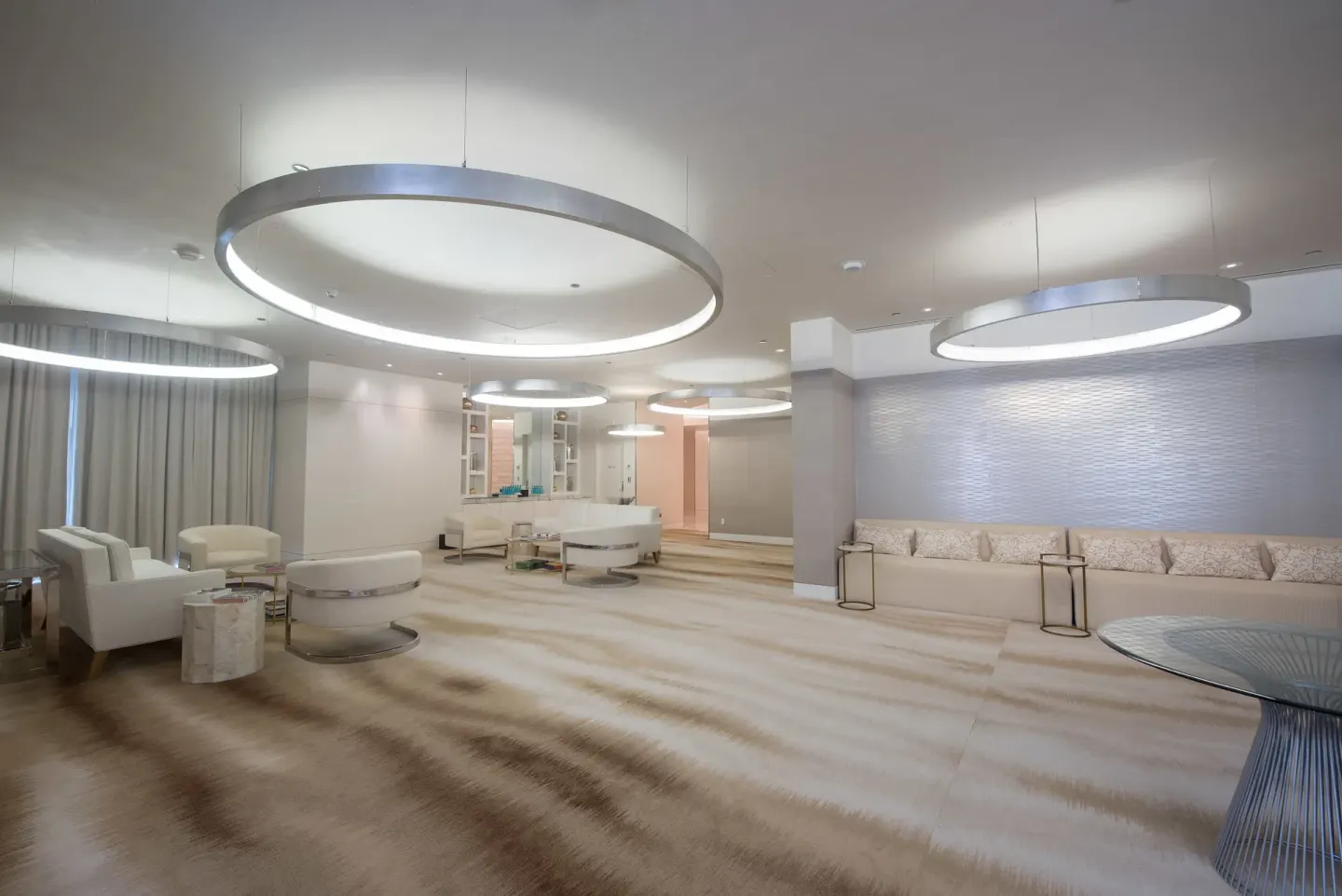 Spa lounge with white seating and ring lights at SLS Baha Mar.