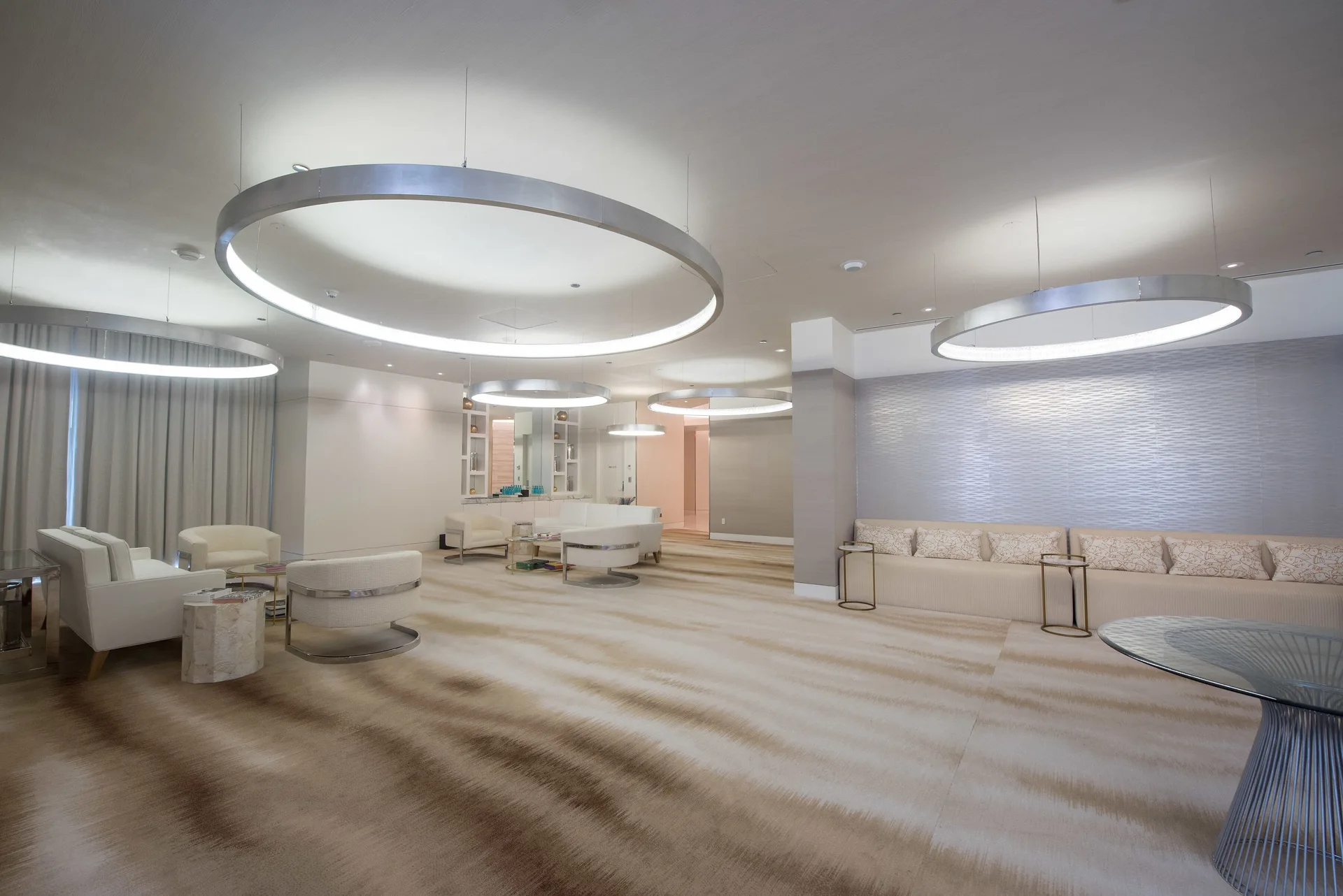 Spa lounge with white seating and ring lights at SLS Baha Mar.
