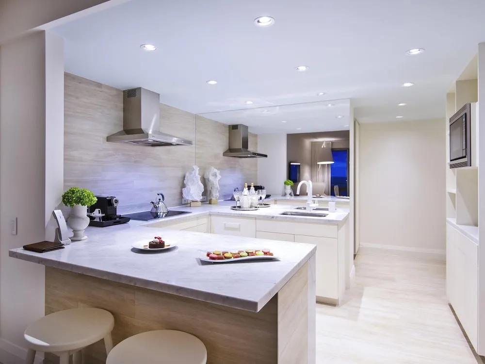 Bright suite kitchen with marble island and stools at SLS Baha Mar.