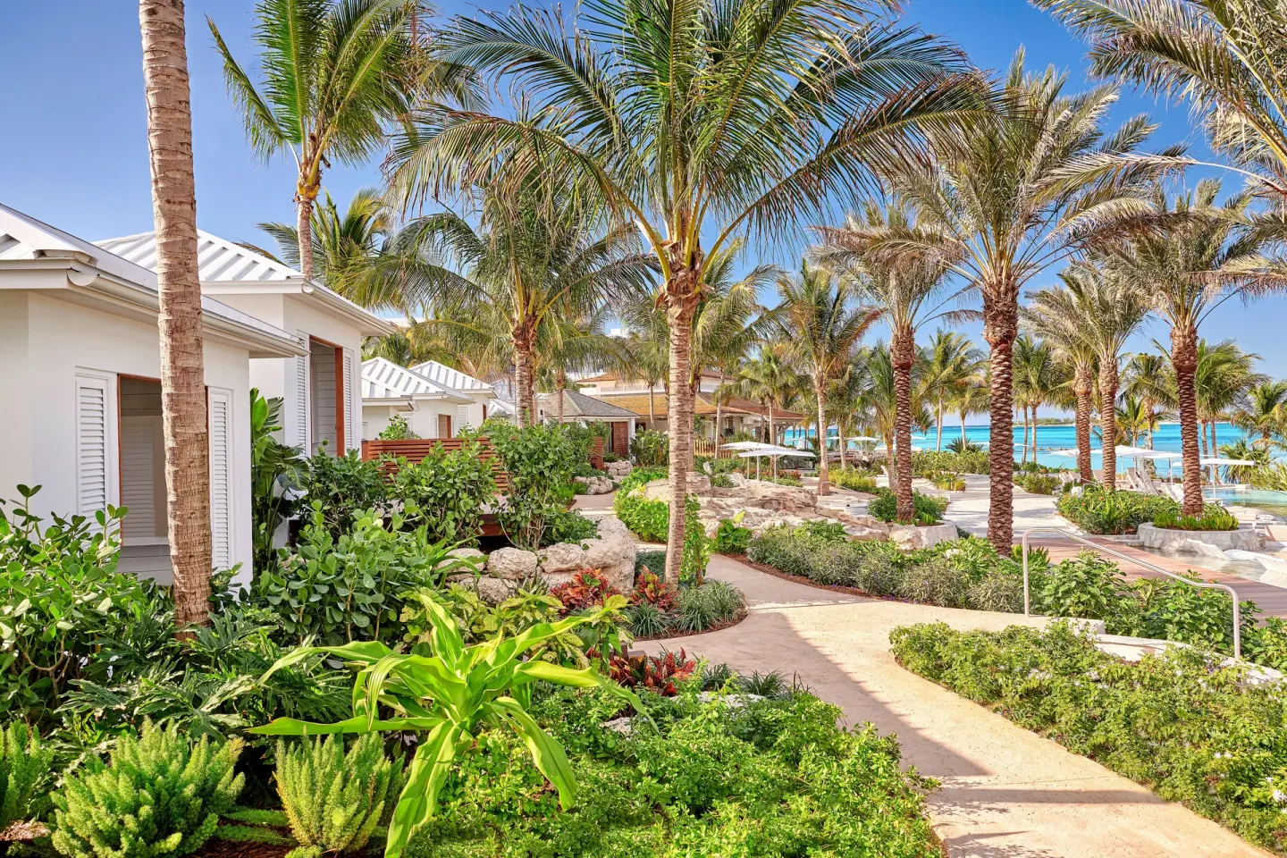 Garden paths wind through palms and low white buildings near the beach at SLS Baha Mar.