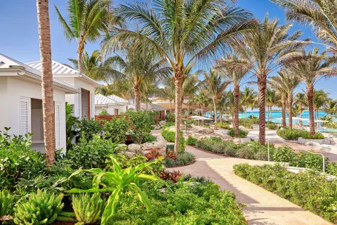 Garden paths wind through palms and low white buildings near the beach at SLS Baha Mar.