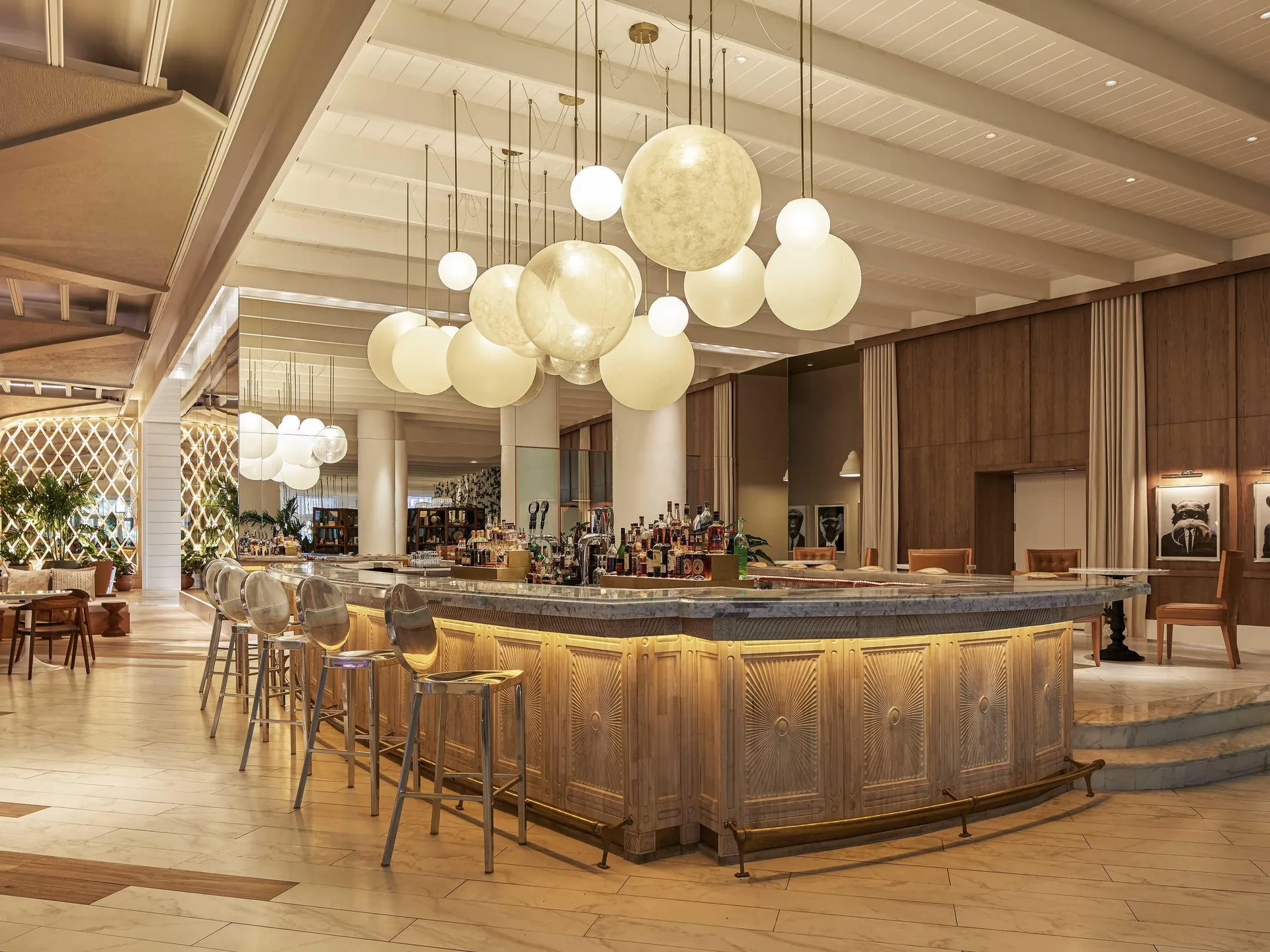 Lobby bar with globe pendant lights and bar stools at SLS Baha Mar.