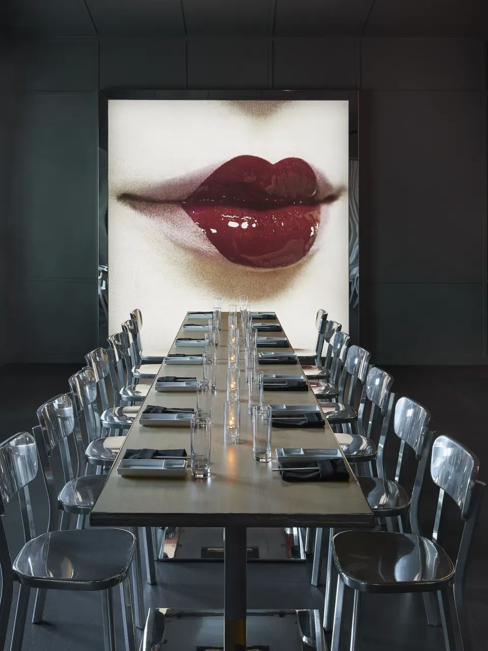 Private dining table with glossy chairs and lip artwork at SLS Baha Mar.