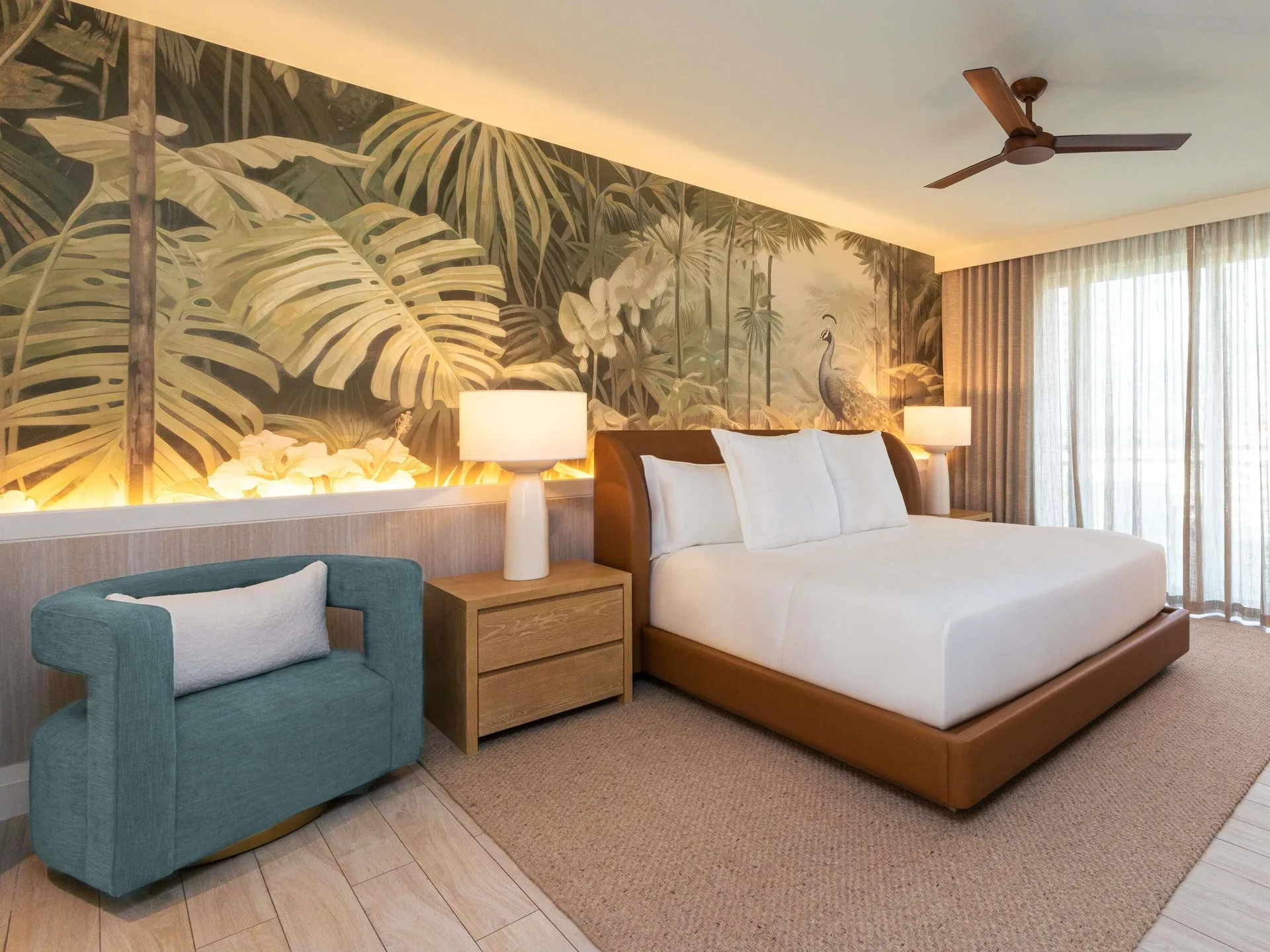 Accessible Superior king guest room with tropical mural and teal chair at SLS Baha Mar.