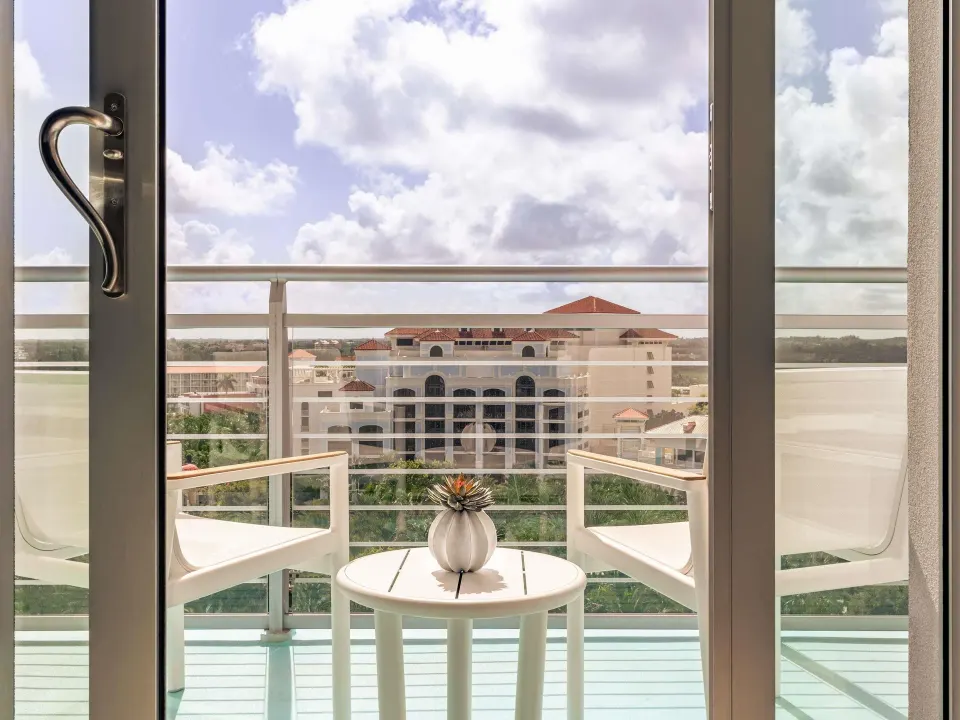 Ocean View One Bedroom Residence balcony at SLS Baha Mar with chairs, table, and resort view.