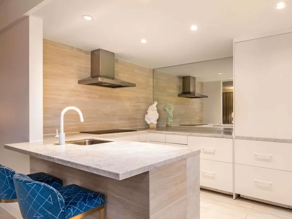 Ocean View One Bedroom Residence kitchen at SLS Baha Mar with marble counter and blue stools.