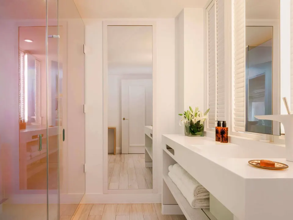 Bright bathroom vanity and glass shower in an Ocean View Two Bedroom Suite at SLS Baha Mar.