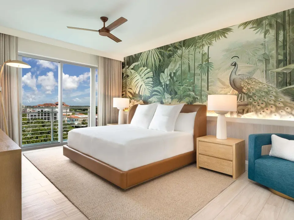 Superior Suite bedroom with king bed, mural wall, and balcony at SLS Baha Mar.